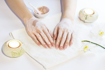 Beautiful woman hands applying pink clay mask