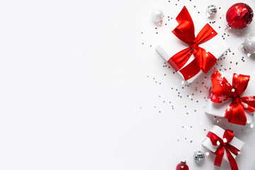Christmas and New Year holiday background. Xmas greeting card. Christmas red ribbon gifts and ornaments on white background top view