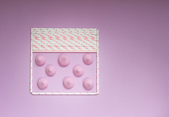 Frame from pink drinking ecofriendly straws with small pink meringues. Valentine’s Day concept.