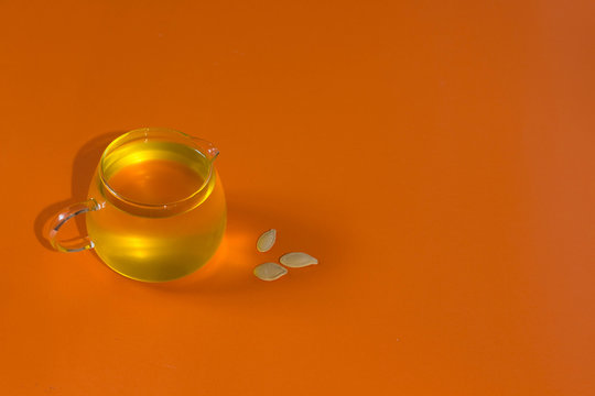 Pumpkin oil isolated on orange background with creative copy space minimalism autumn concept