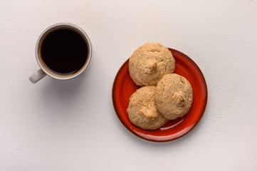 Almond biscuits on a plate and a cup of tea on light background. Top view