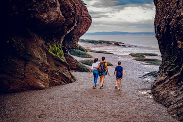 Familly people walking at Sunset in Hopewell Rocks at low tide