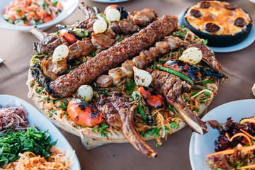 Traditional Turkish Adana kebab or kebap meat food, appetizers, raki and salgam on table from top view in turkish restaurant.	