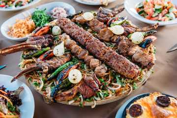 Traditional Turkish Adana kebab or kebap meat food, appetizers, raki and salgam on table from top...