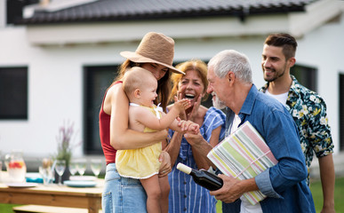 Portrait of multigeneration family outdoors on garden barbecue.