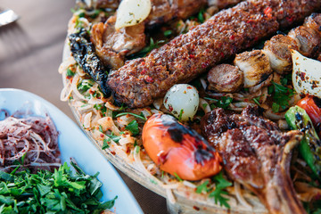 Traditional Turkish Adana kebab or kebap meat food, appetizers, raki and salgam on table from top view in turkish restaurant.	