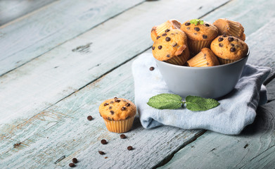 Chocolate vanilla fresh delicious muffins on blue wooden background
