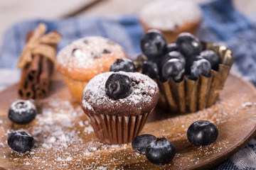 Blueberry and chocolate muffins on wooden background