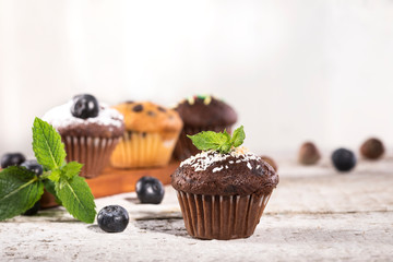 Blueberry and chocolate muffins on white wooden background