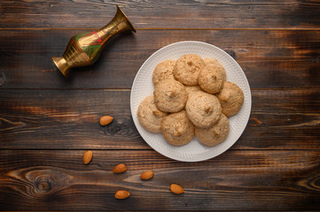 Almond biscuits on a plate on a wooden table. Top view