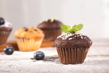 Blueberry and chocolate muffins on white wooden background