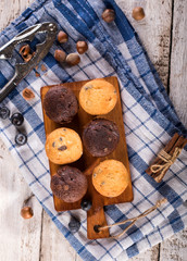 Blueberry and chocolate muffins on white wooden background