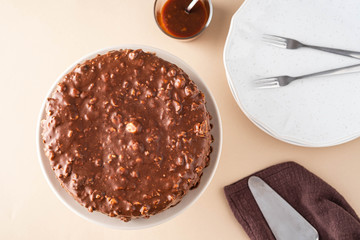 Chocolate cake with nuts and caramel on a light background.