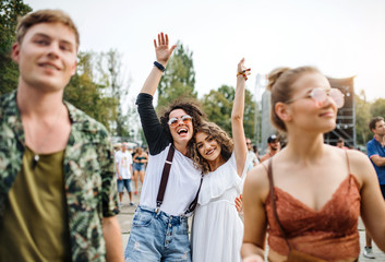 Front view portrait of group of young friends dancing at summer festival.