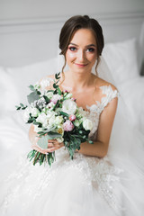 Naklejka premium Luxury wedding bride, girl posing and smiling with bouquet