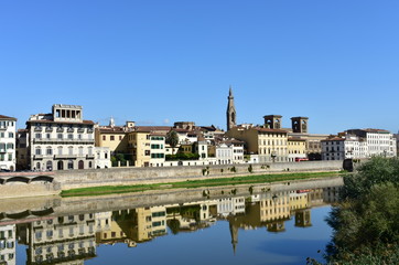 View of Arno River with Basilica di Santa Croce bell tower and water reflection. Florence, Italy.