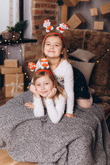 Close up portrait of cheerful happy cute caucasian girls in merry christmas decorated holiday cozy home. Childhood, new year, kids leisure concept