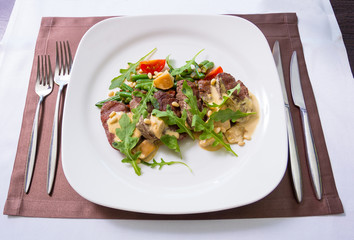beef tenderloin garnished with green beans and cherry tomatoes