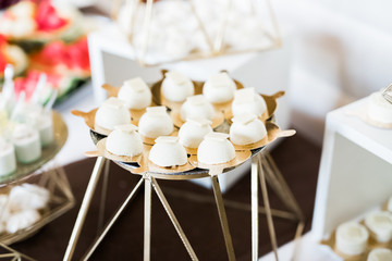 Delicious sweets on wedding candy buffet with desserts, cupcakes