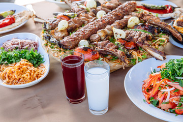 Traditional Turkish Adana kebab or kebap meat food, appetizers, raki and salgam on table from top view in turkish restaurant.	