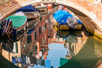 Fototapeta na wymiar Reflection in the water channel of Venice, Italy