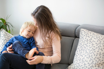 Mother, tickling her little toddler boy, child giggling at home