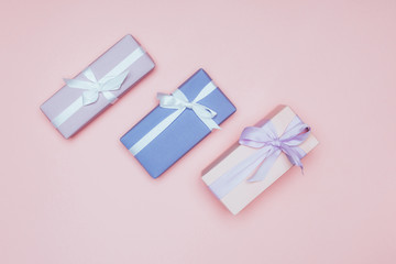 top view of christmas gift boxes with ribbons, isolated on pink