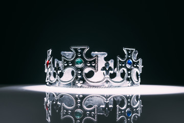 antique silver crown with gemstones on black