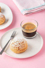 Craquelin Choux biscuits with cream filling on a pink background.