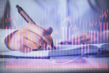 Multi exposure of woman's hands making notes with forex graph hologram. Concept stock market...
