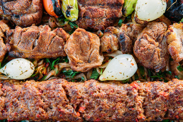 Traditional Turkish Adana kebab or kebap meat food, appetizers, raki and salgam on table from top view in turkish restaurant.	