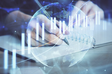 Forex graph on hand taking notes background. Concept of research. Double exposure