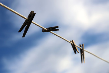 Wooden clothespins on the rope. Cloth clips hanging in the rope and waiting for the next batch of clothes