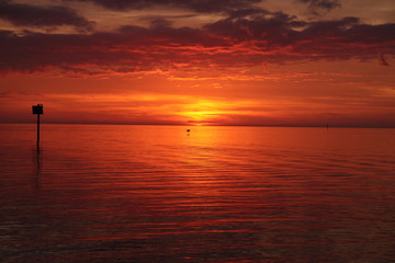 Fototapeta na wymiar Crimson red sunset on the beach in Florida in winter