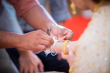 bind holy thread with hand in thai rite.The bride's hands are tied with thread from the older culture in Thailand.