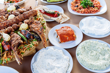 Traditional Turkish Adana kebab or kebap meat food, appetizers, raki and salgam on table from top view in turkish restaurant.	