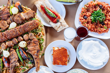 Traditional Turkish Adana kebab or kebap meat food, appetizers, raki and salgam on table from top view in turkish restaurant.	