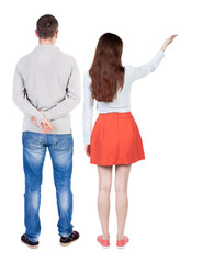 Back view of a stylish couple pointing.