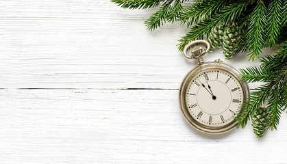 New Year old pocket watch eve to midnight with fir branches and green cones.
