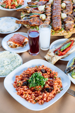 Traditional Turkish Adana kebab or kebap meat food, appetizers, raki and salgam on table from top view in turkish restaurant.	