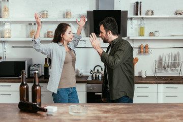 Selective focus of angry woman quarreling with alcohol addicted husband