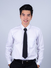 Portrait handsome young asian .businessman wearing a white shirt smile and look happy isolated on grey background in studio. Asian man people. 