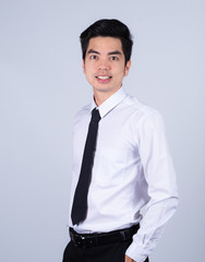 Fototapeta premium Portrait handsome young asian .businessman wearing a white shirt smile and look happy isolated on grey background in studio. Asian man people. 