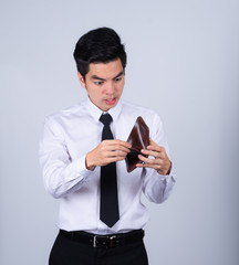 Portrait handsome young asian .businessman wearing a white shirt stressed because empty wallet no money isolated on grey background in studio. Asian man people. business success concept.