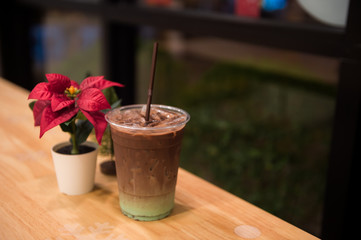 Obraz na płótnie Canvas iced mint chocolate drink in plastic glass, put on a wooden table with christmas theme background
