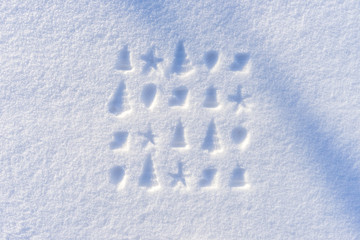 Traces of Christmas decorations on white fresh snow in sunny winter day. Greeting card for New Year...