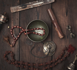 Copper singing bowl, prayer beads, prayer drum and other Tibetan religious objects for meditation...