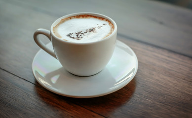 Blurred images of ready-to-drink cappuccino cups placed on a wooden table in the morning as background images and beautiful illustrations