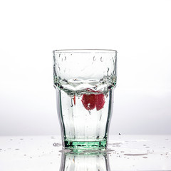 A glass of clean water and fresh red strawberries