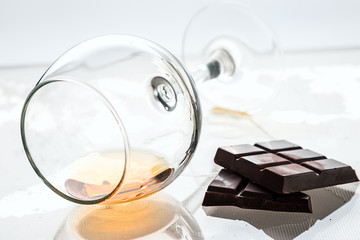 still life of a glass glass with alcohol and chocolate bars.